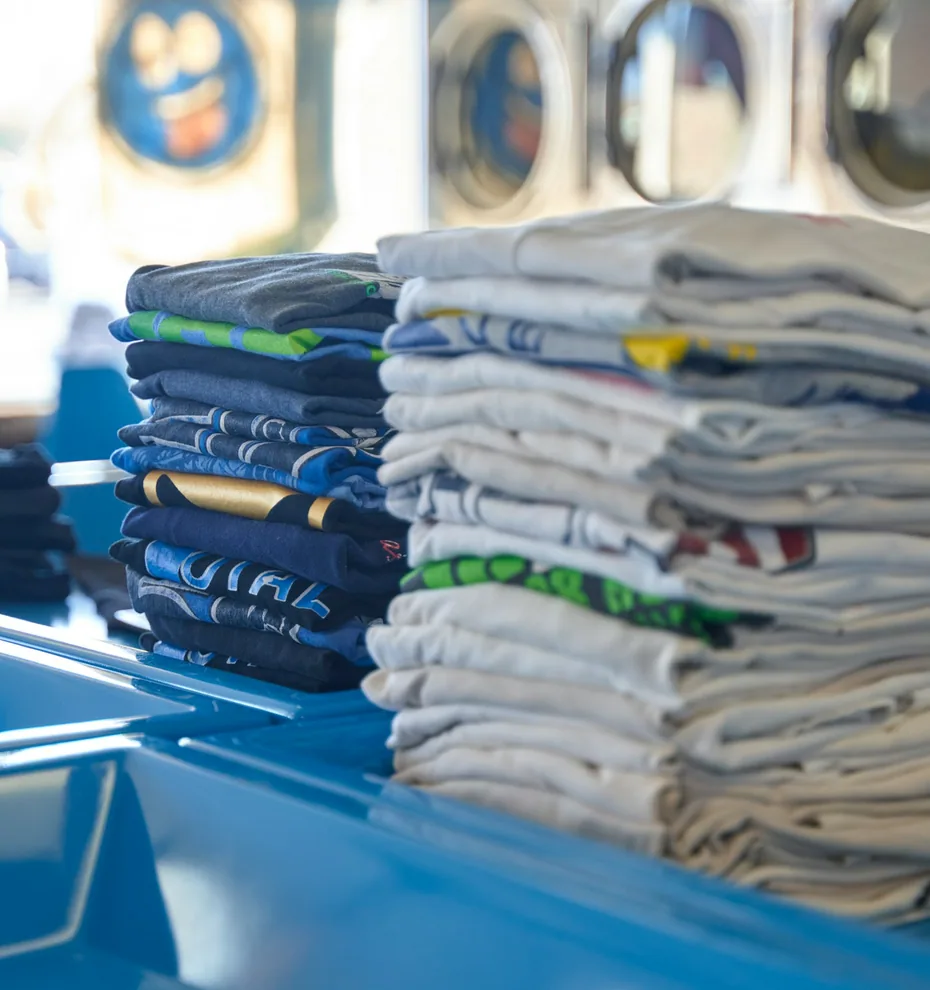 Folded clothes stacked on a laundry counter